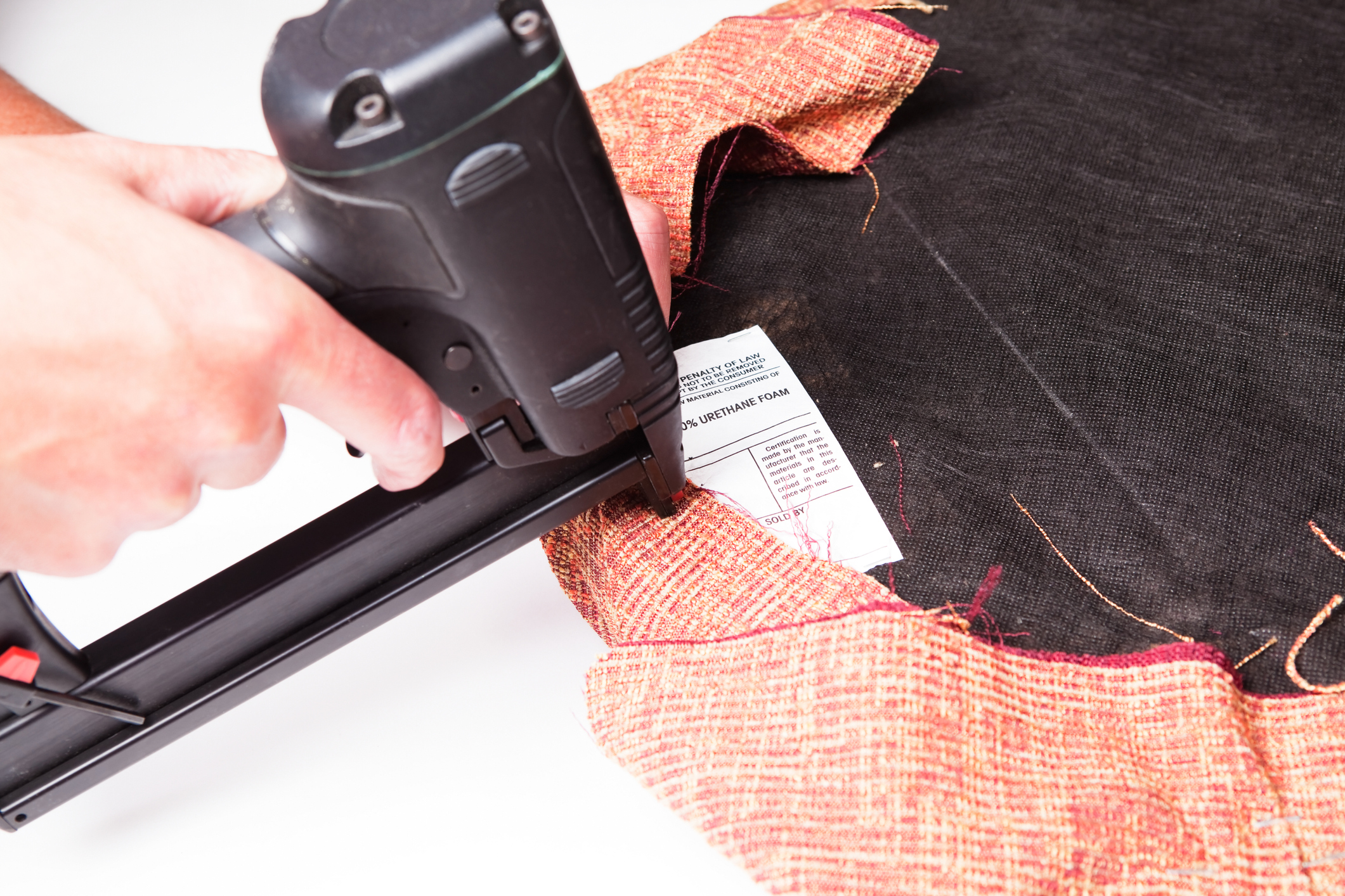 Upholsterer Installing Fabric on Seat Cushion with Air Stapler